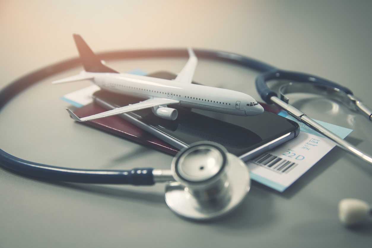 A stethoscope is placed around an airplane and passport, representing travel after bariatric surgery.