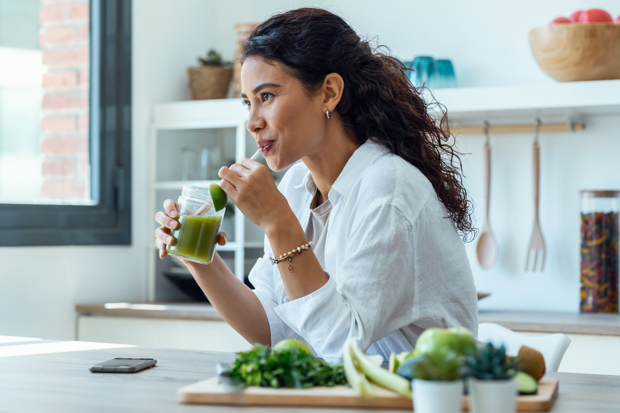 Is Gastric Sleeve Permanent? Woman looking sideways while drinking fruit detox juice in the kitchen at home.