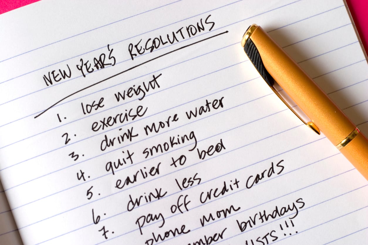 A list of New Year’s resolutions on notebook paper with “lose weight” and “exercise” in the top two spots.