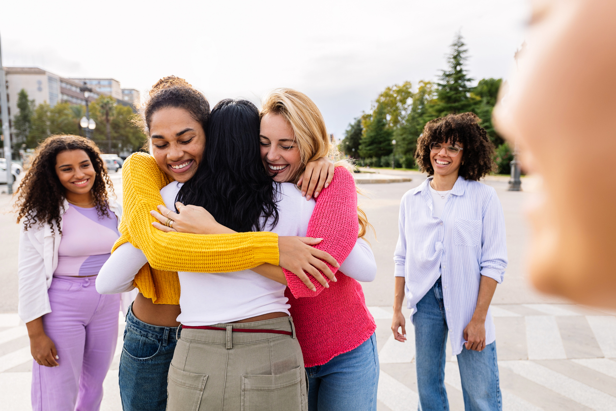 A group of friends hug one another in support after bariatric surgery